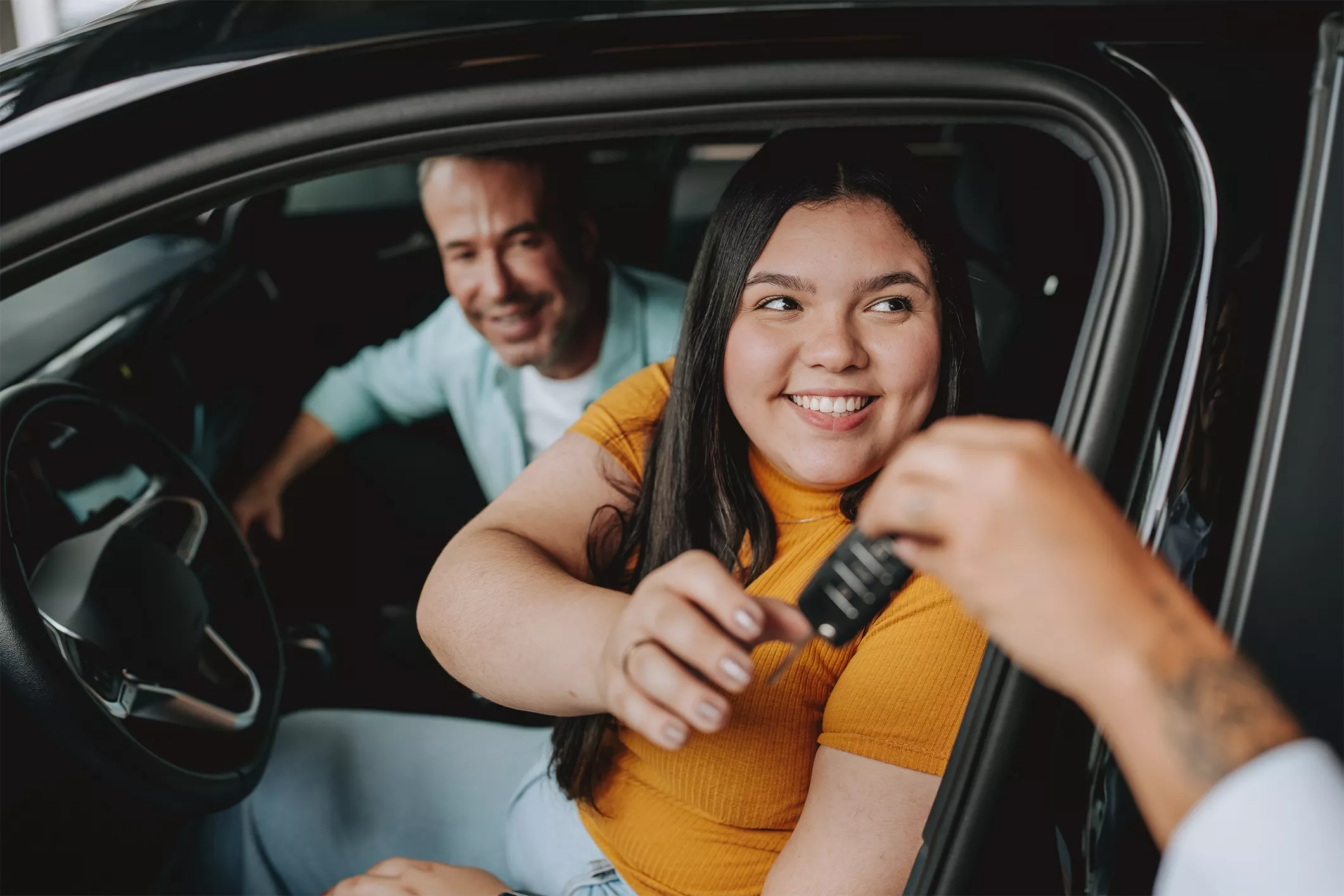 A lady in a car being handed the keys
