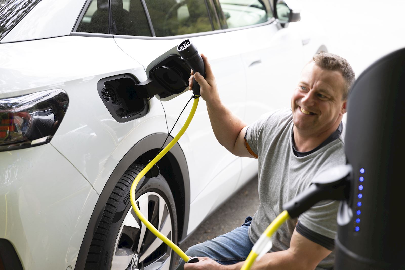 A man happily charging his EV