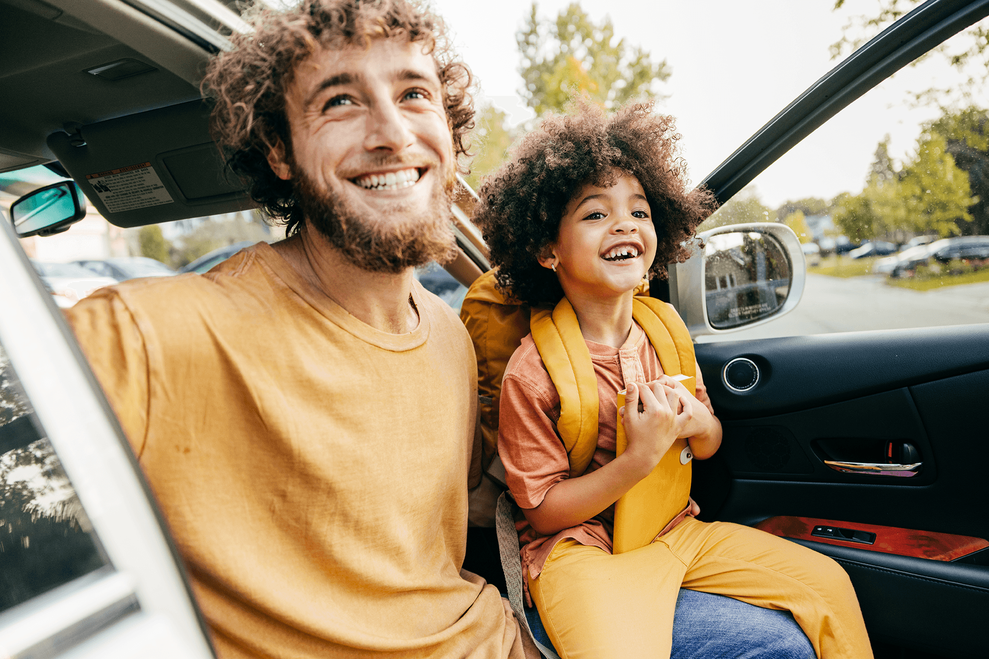 Man and child sitting happily in a Motability vehicle