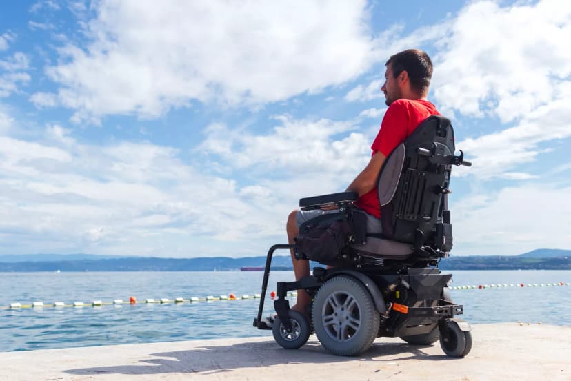 man in powered wheelchair looking at the water